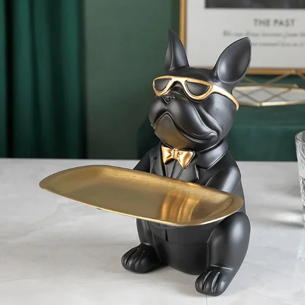 Decorative statue of a dog wearing sunglasses and a bow tie, holding a gold tray.